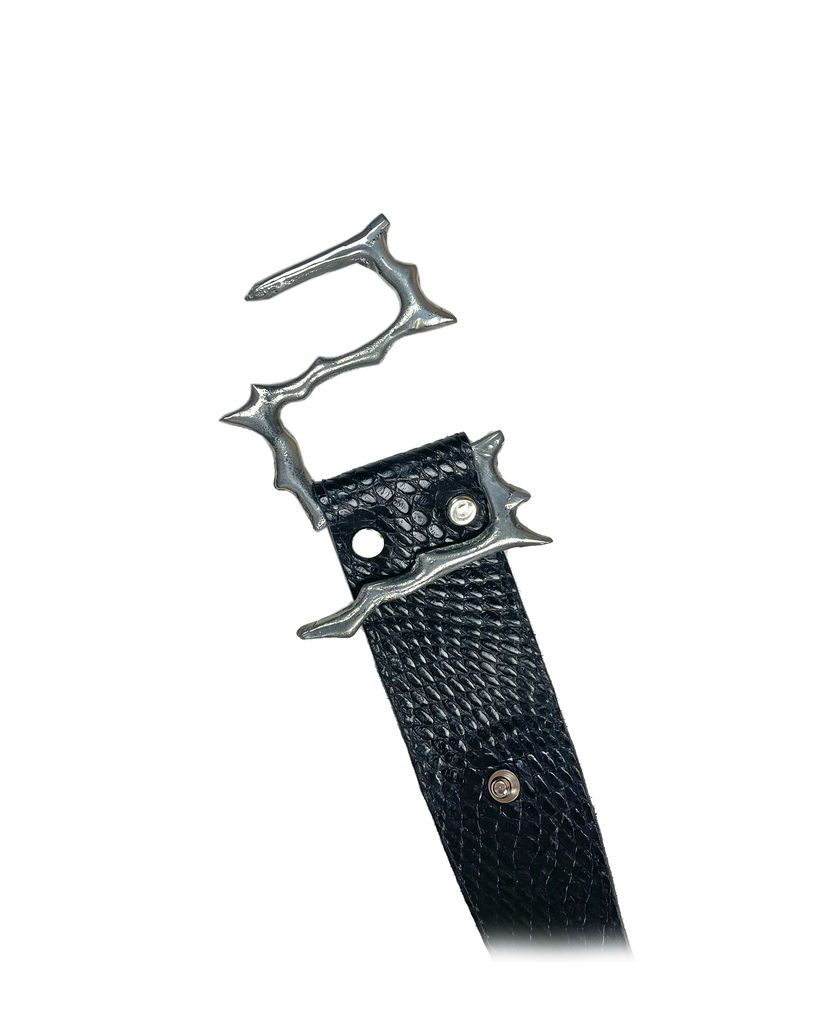 Black reptile print leather belt with silver aluminium buckle shaped like thorns and lightning on a white background