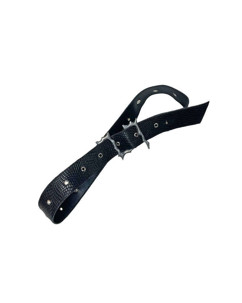 Black reptile print leather belt with silver aluminium buckle shaped like thorns and lightning on a white background