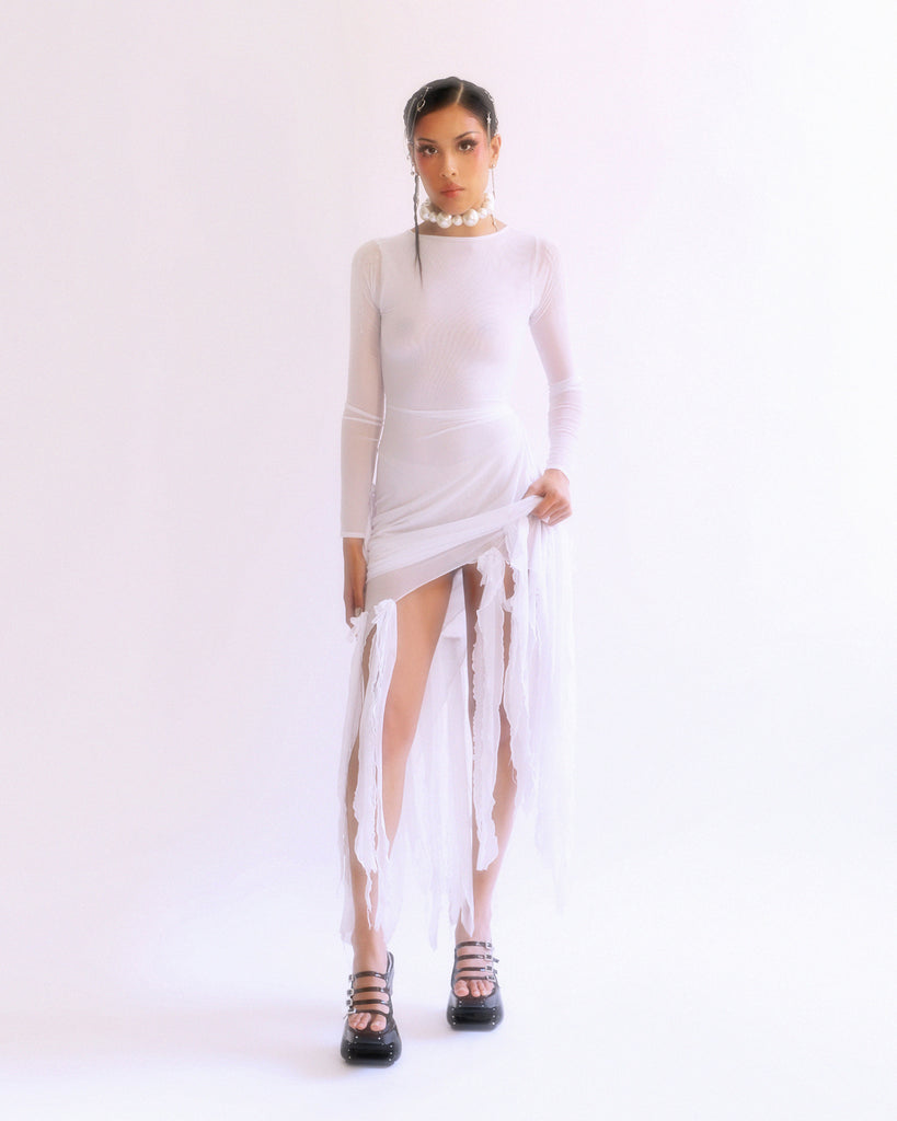 model wearing white dress and black platform shoes against white background