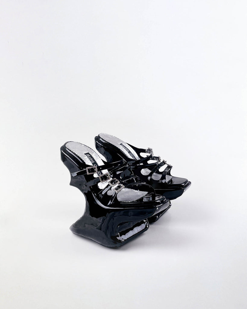 black strappy chopine platform shoes against white background