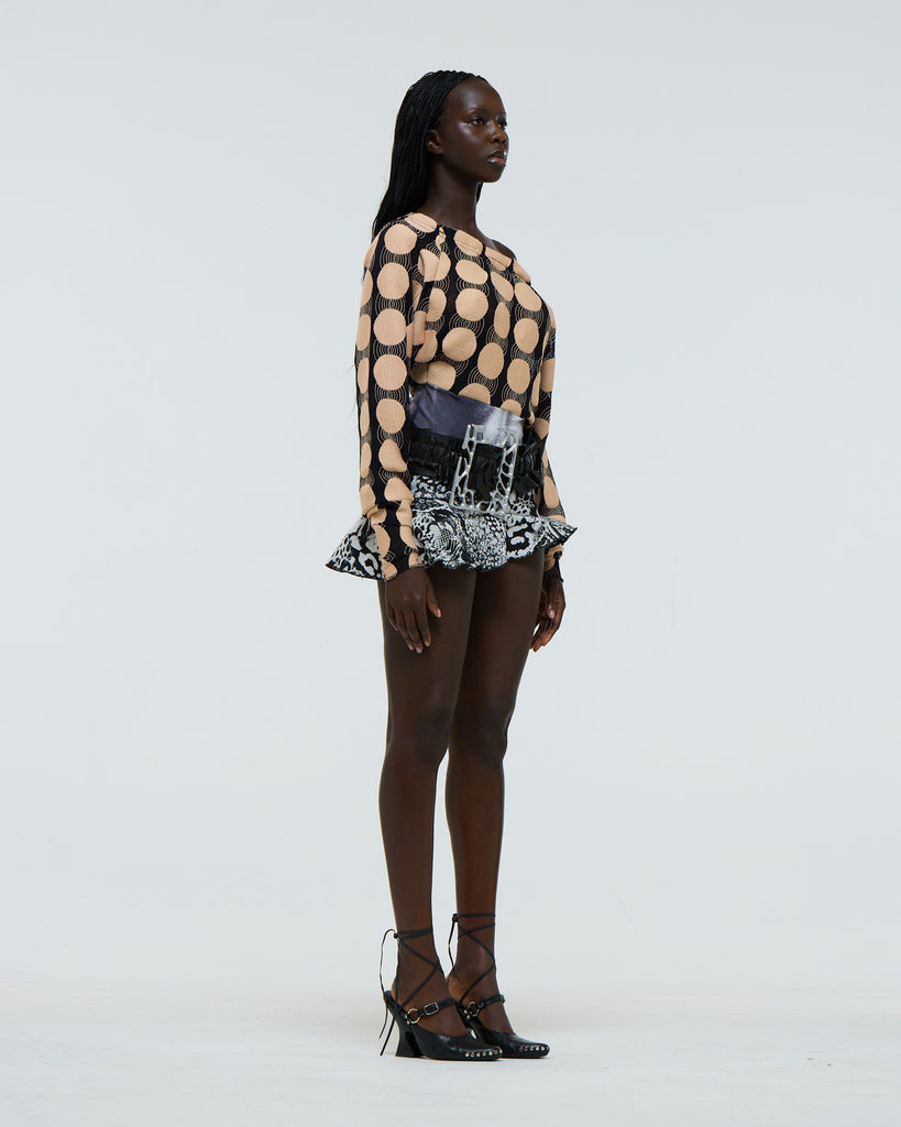 Model wearing a patterned outfit on a white background