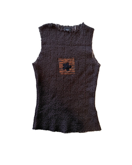 A sleeveless, textured knit top in a very dark brown featuring a small square patch on the chest with a black flower motif over a brown and orange striped background.