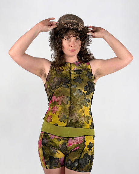 Person wearing a sleeveless top and shorts with floral pattern on a white background
