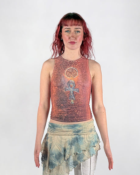 Woman wearing a sleeveless mesh top with an Ankh symbol on a white background