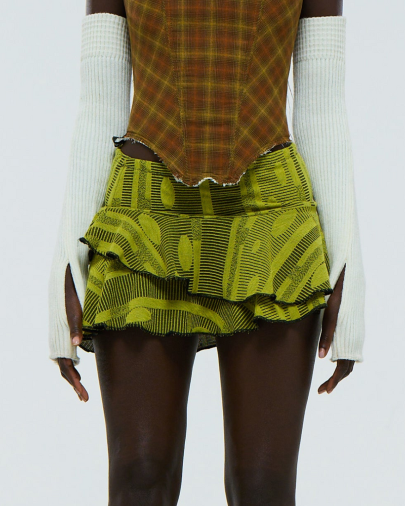 Green yellow geometric patterned stretch skirt worn by a model on a white background